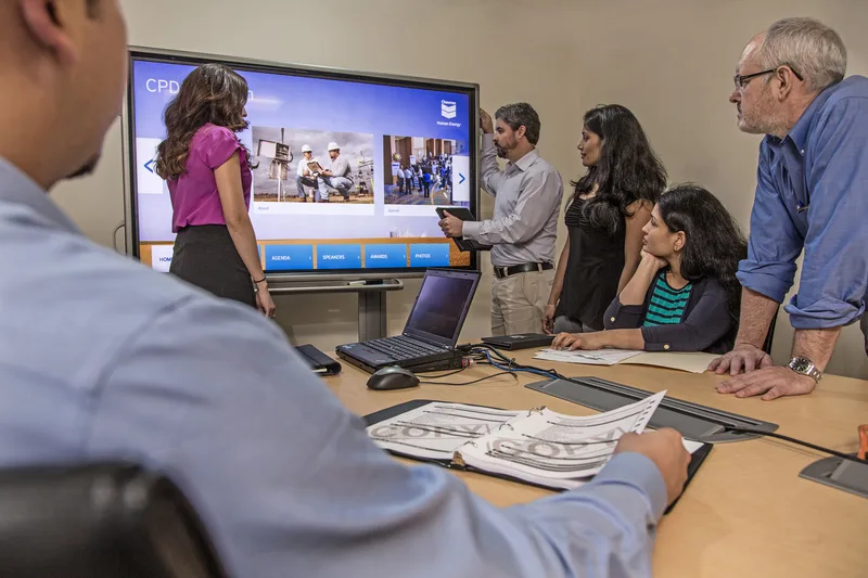 Corporate lifestyle team reviewing presentation on large conference room display