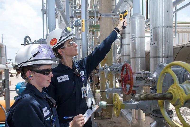 styrene plant inspection team scanning aluminum-jacketed pipes with infrared thermometer
