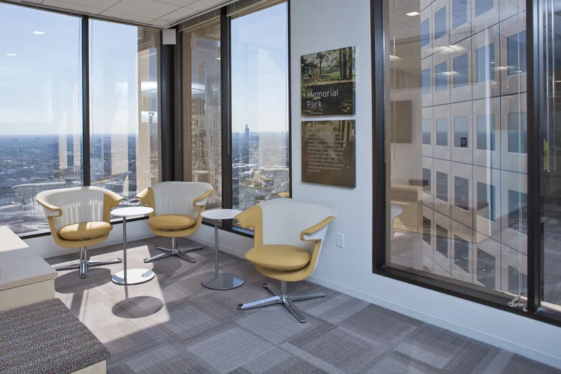 Corporate breakaway lounge with gold swivel chairs bistro tables and skyline views