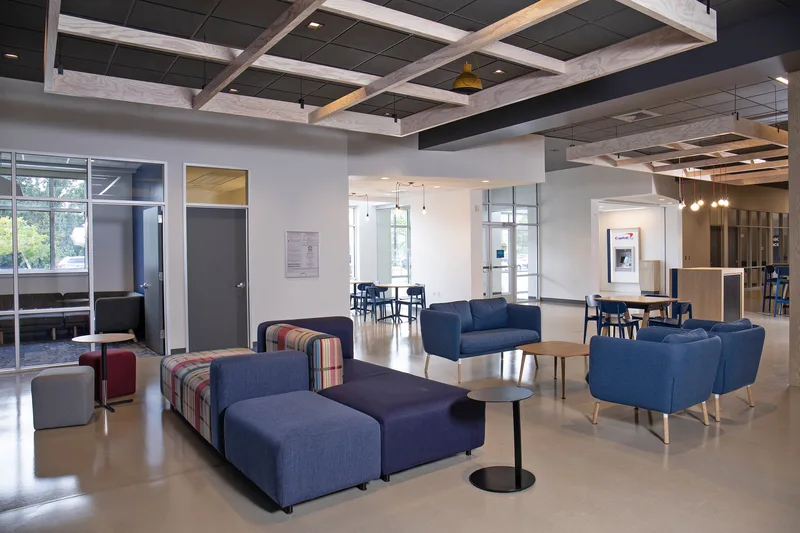Corporate portrait environment modern bank lobby blue sectional exposed beam ceiling