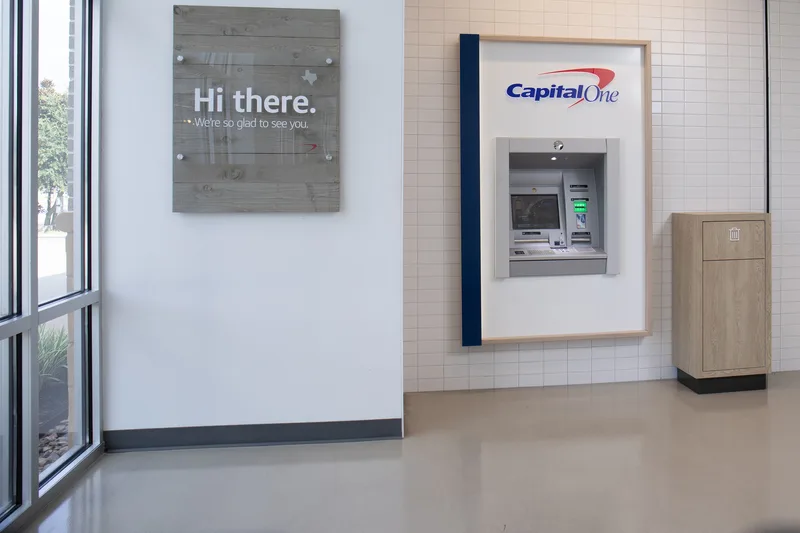 Capital One bank interior wall-mounted ATM beside welcoming lobby signage