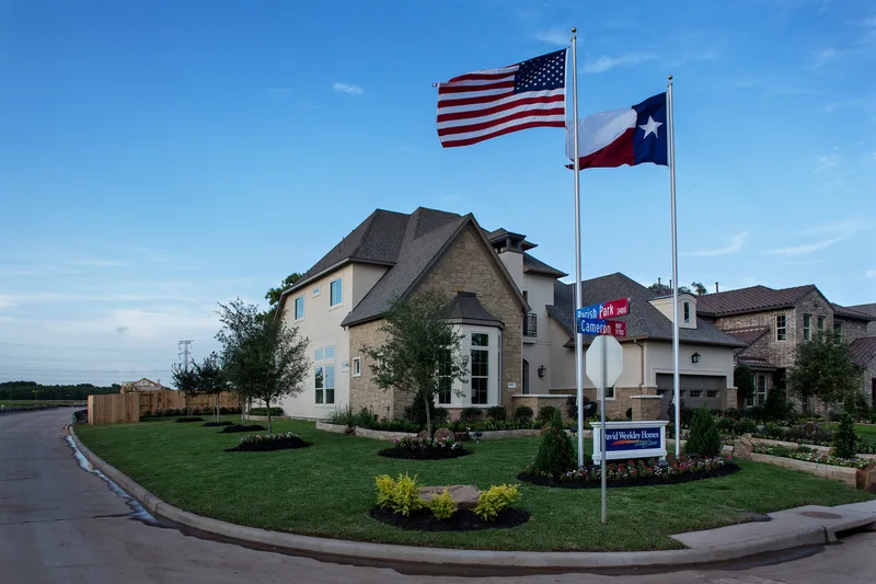 Environmental lifestyle photography of luxury home with patriotic flags and landscaping
