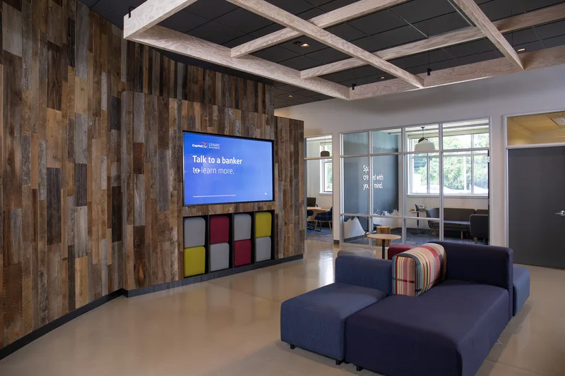 corporate banking lobby reclaimed wood wall colorful cube ottomans blue sofa