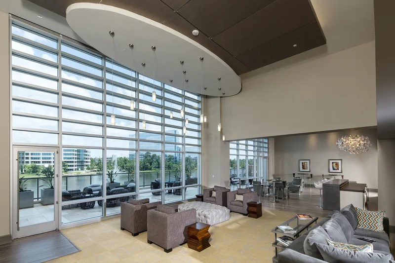 Hi-rise residential lounge showcasing floor-to-ceiling glass walls and upscale contemporary furnishings