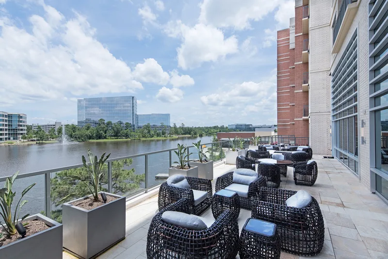 luxury waterfront terrace wicker lounge seating overlooking lake and glass towers