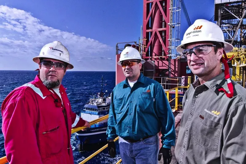 Environmental portraits of three offshore oil platform workers in safety gear