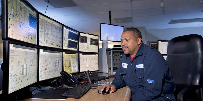 styrene control room environmental portrait professional at multi-monitor industrial workstation