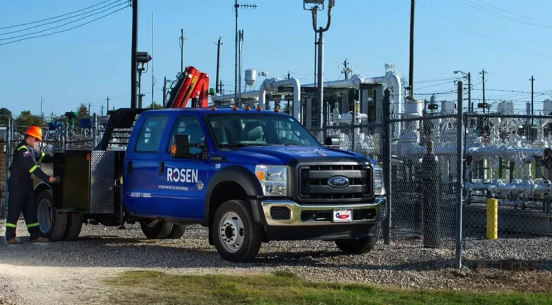 ROSEN technician servicing utility equipment from blue flatbed work truck