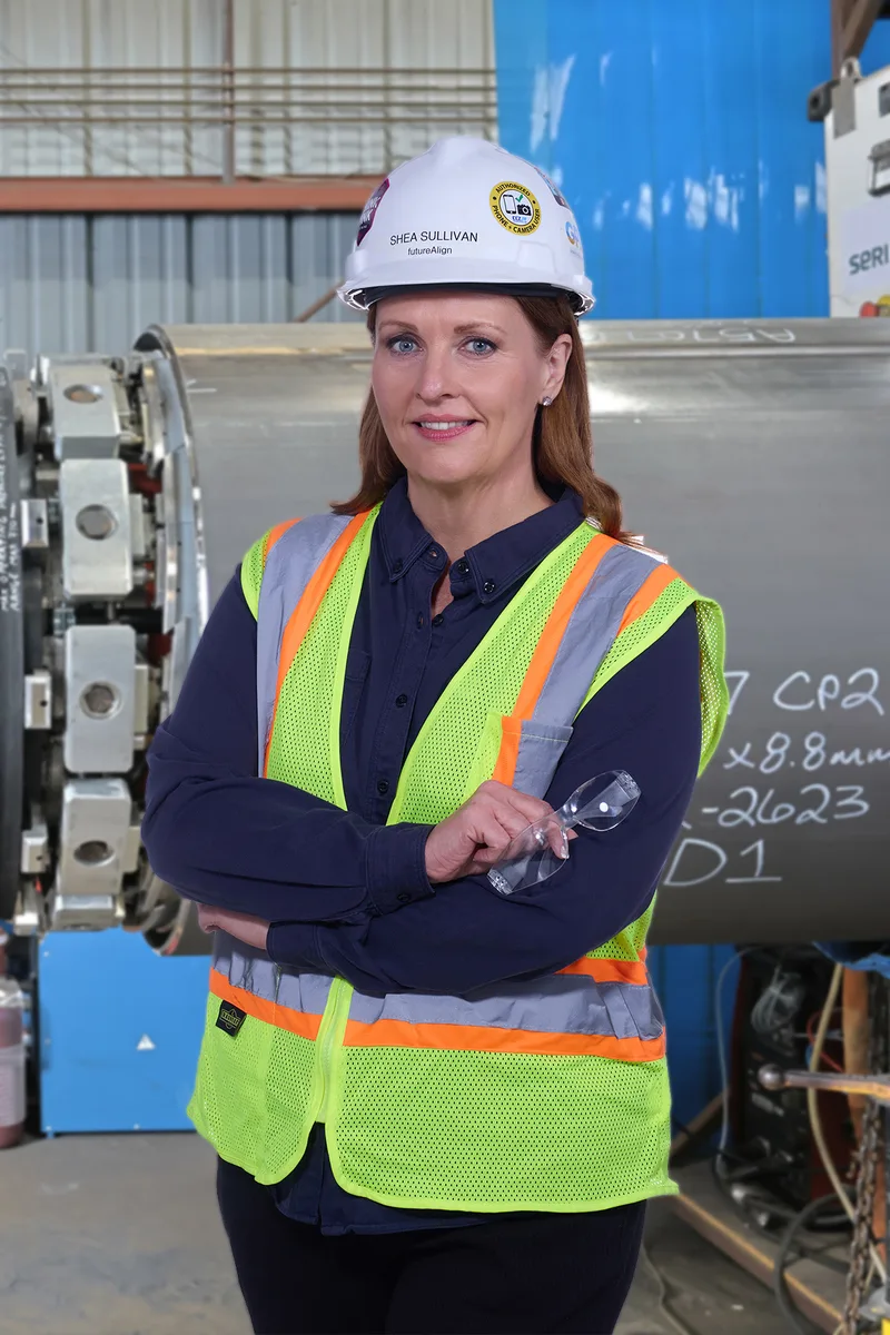 Industrial environmental portrait woman hard hat reflective vest steel pipe machinery