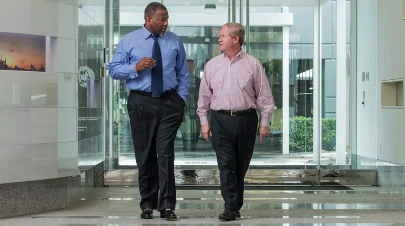 Two executives walking through modern corporate office lobby