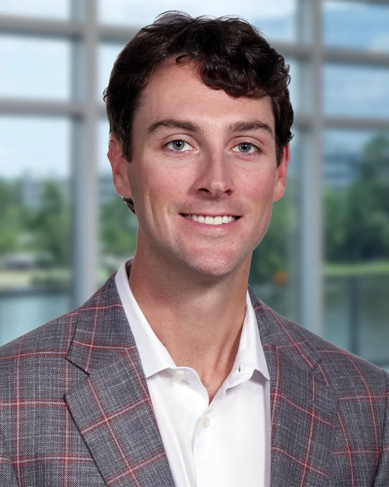 Executive portrait man gray plaid sport coat white polo indoor window background