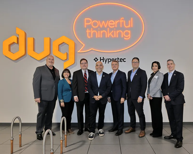 Grand opening executive group portrait posed before branded neon sign wall