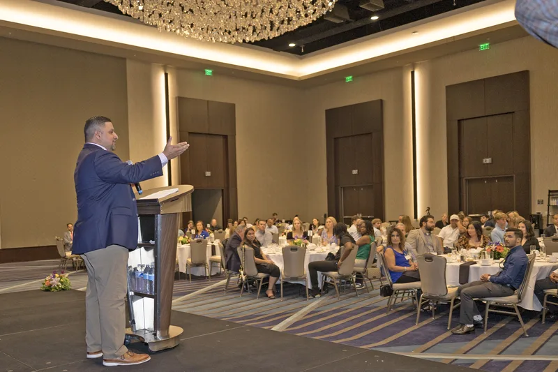 presenter addressing maritime scholarship awards dinner guests in chandelier ballroom