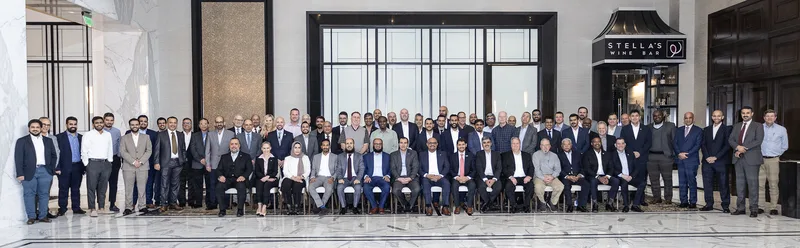 Corporate event group portrait of suited executives and professionals in hotel atrium