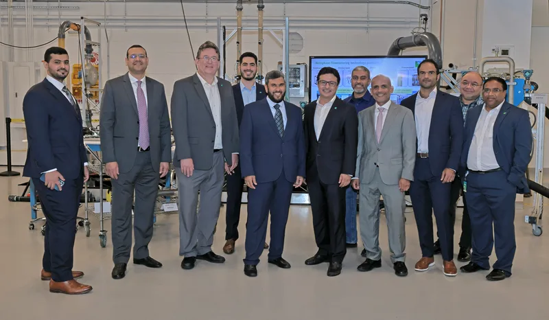 suited executives gathered inside industrial flowmetering research laboratory for group portrait