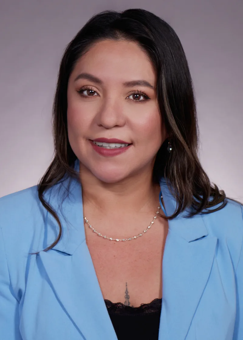 Corporate headshot woman blue blazer silver necklace soft studio backdrop