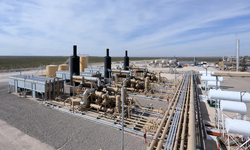 LNG compression station black steel exhaust stacks tan painted pipe manifold array