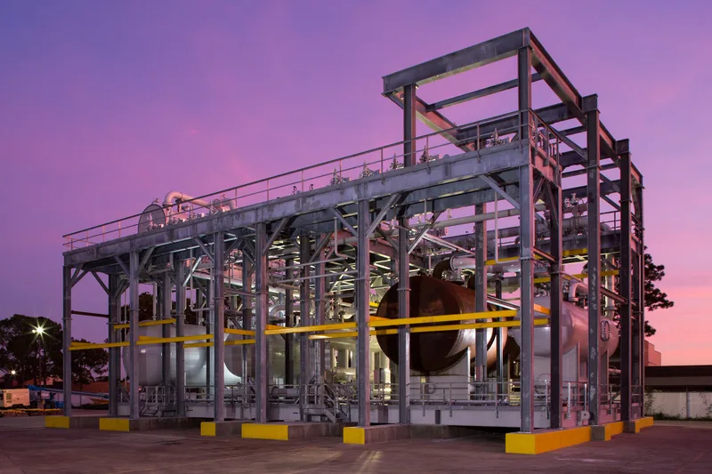Enerflex modular processing skid with galvanized framework, pressure vessels, and yellow safety barriers