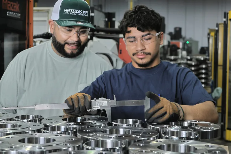 Industrial quality control inspection using precision calipers on machined steel flanges