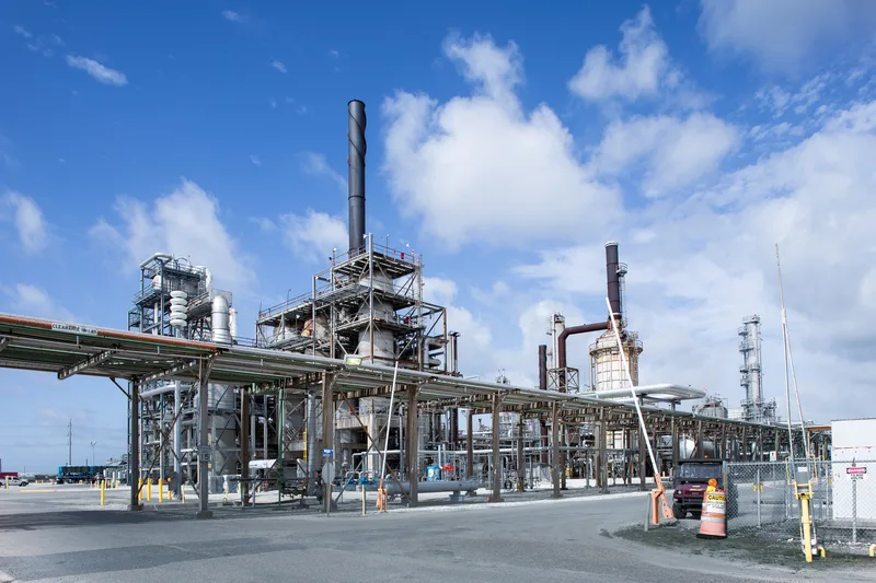 Styrene production complex with black metal stacks and galvanized pipe racks